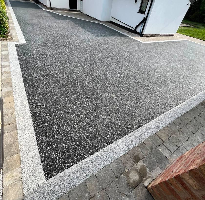 Black resin bound driveway with a silver decorative border